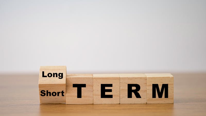Flipping od wooden cube block for change short term to long term. Business investment concept.